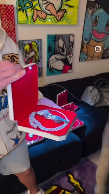 Jewelry and grillz presented in red display boxes, from the original video